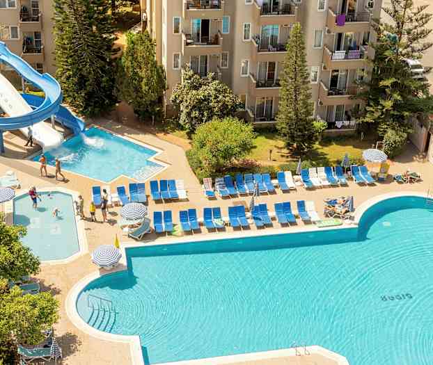 Udendørs poolområde ved en bygning, med vandrutsjebane og liggestole. (AI-genereret tekst)