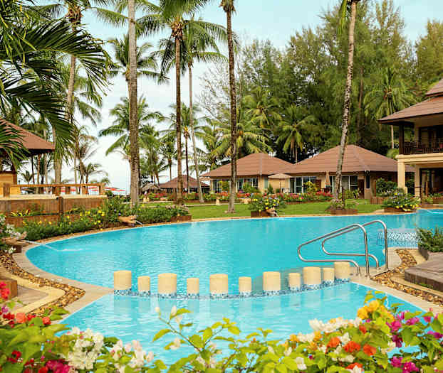 Ferieområde med swimmingpool, omkringliggende have og palmer. (AI-genereret tekst)