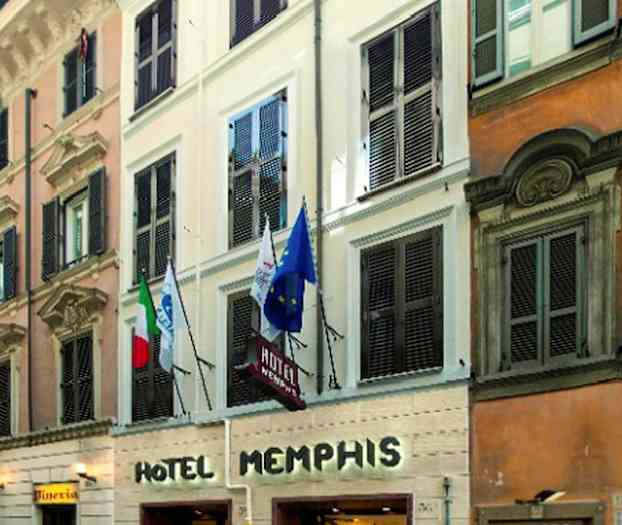 Facaden af Hotel Memphis med indgang i gadeplan og flag synlige over. (AI-genereret tekst)