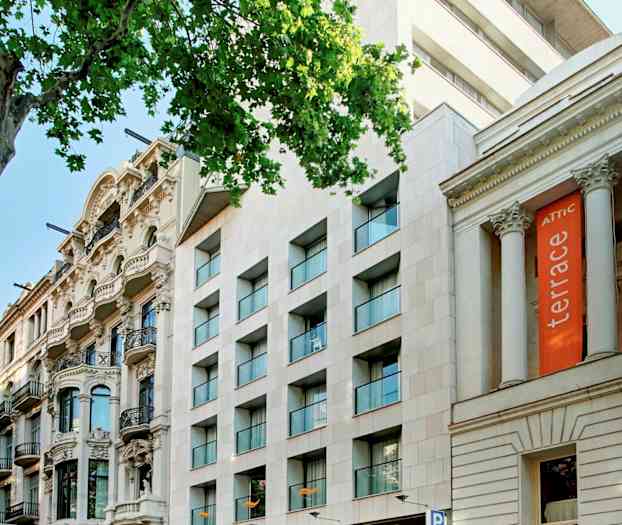 En gade med flere bygninger, herunder et hotel med skiltet "Citadines" og andre arkitektoniske stilarter. (AI-genereret tekst)