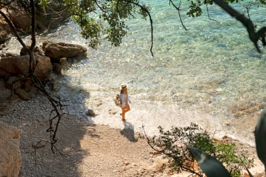 Kvinde går ved havet i Kroatien