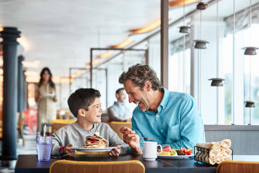Far og søn spiser mad på krydstogtskib