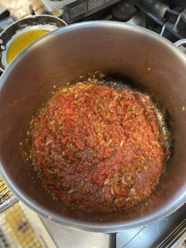 løg og tomater i en gryde