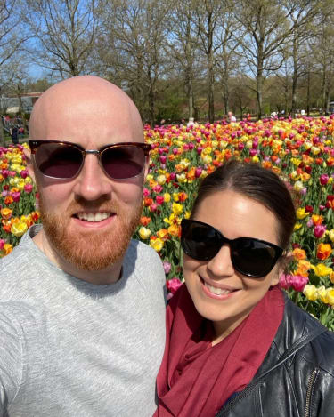 Sarah og hendes mand foran tulipaner