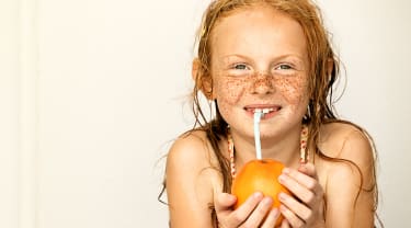 Pige drikker af appelsin