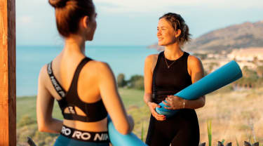 To kvinder med yogamåtter på en træningsrejse