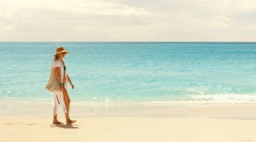 Kvinde går på stranden i Aruba