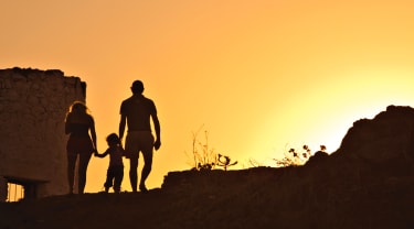 Mor, barn og far i solnedgang