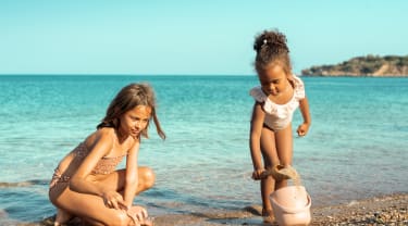 To piger leger på en strand