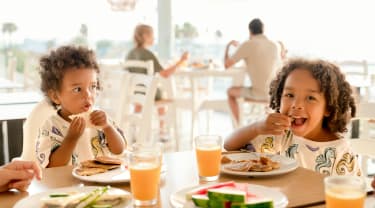 To børn spiser mad i restaurant