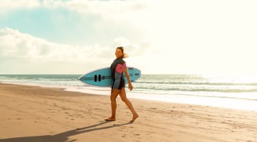 Pige surfer på stranden