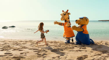 Lollo & Bernie sammen med et barn på stranden