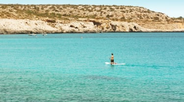 Mand på padelboard i en bugt på Cypern