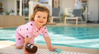 Lille pige leger ved poolen