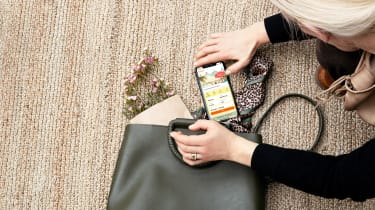 Kvinde lægger mobiltelefon ned i sin taske