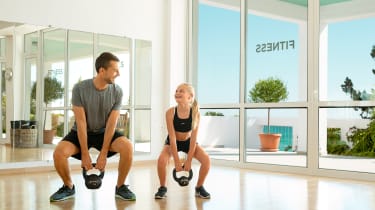 Far og datter løfter vægte - aktiv ferie med børn
