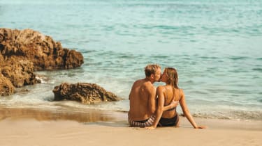 Par på en strand er på romantisk ferie med Spies