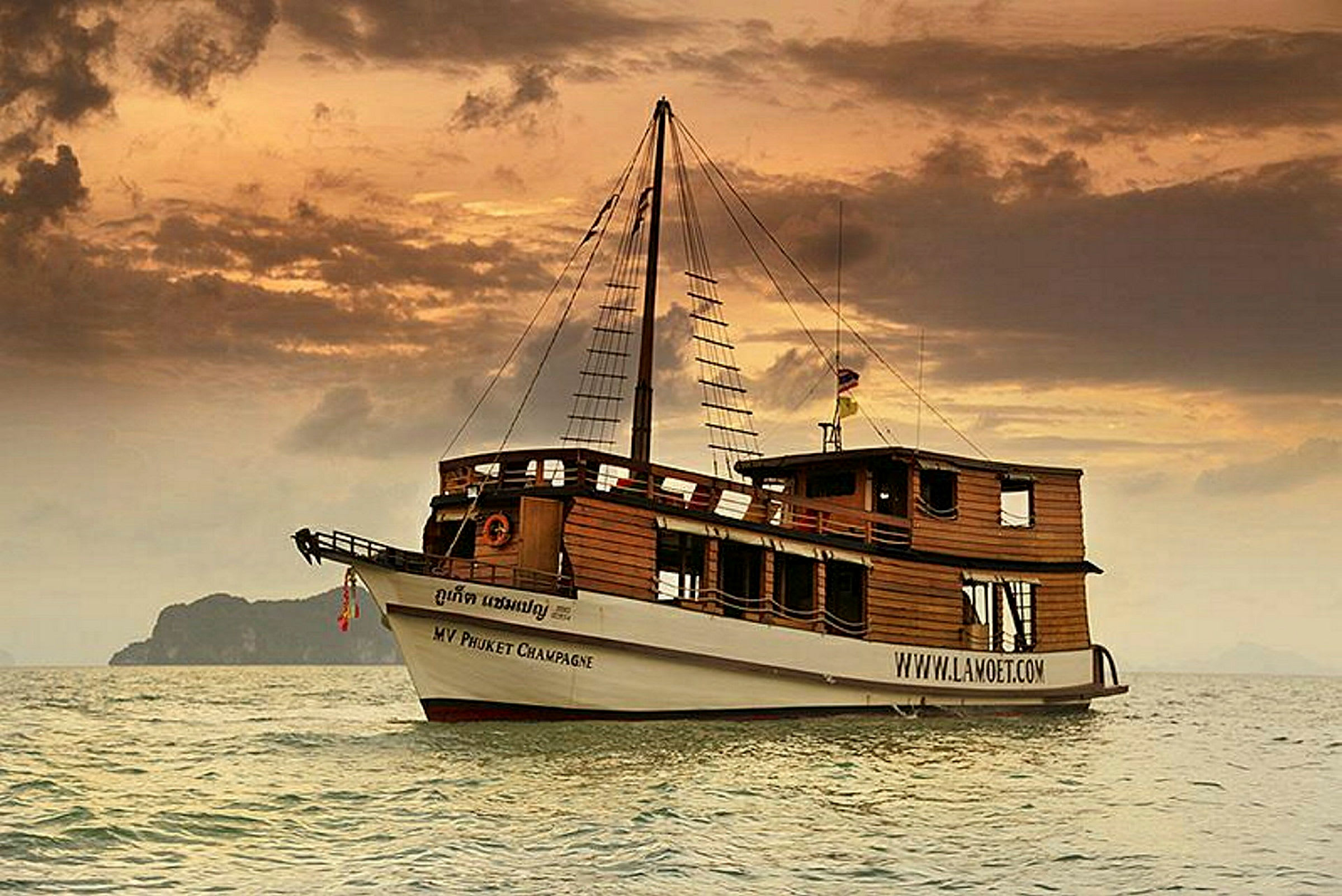 Et traditionelt træskib med sejlstruktur ses på havet ved solnedgang. (AI-genereret tekst)