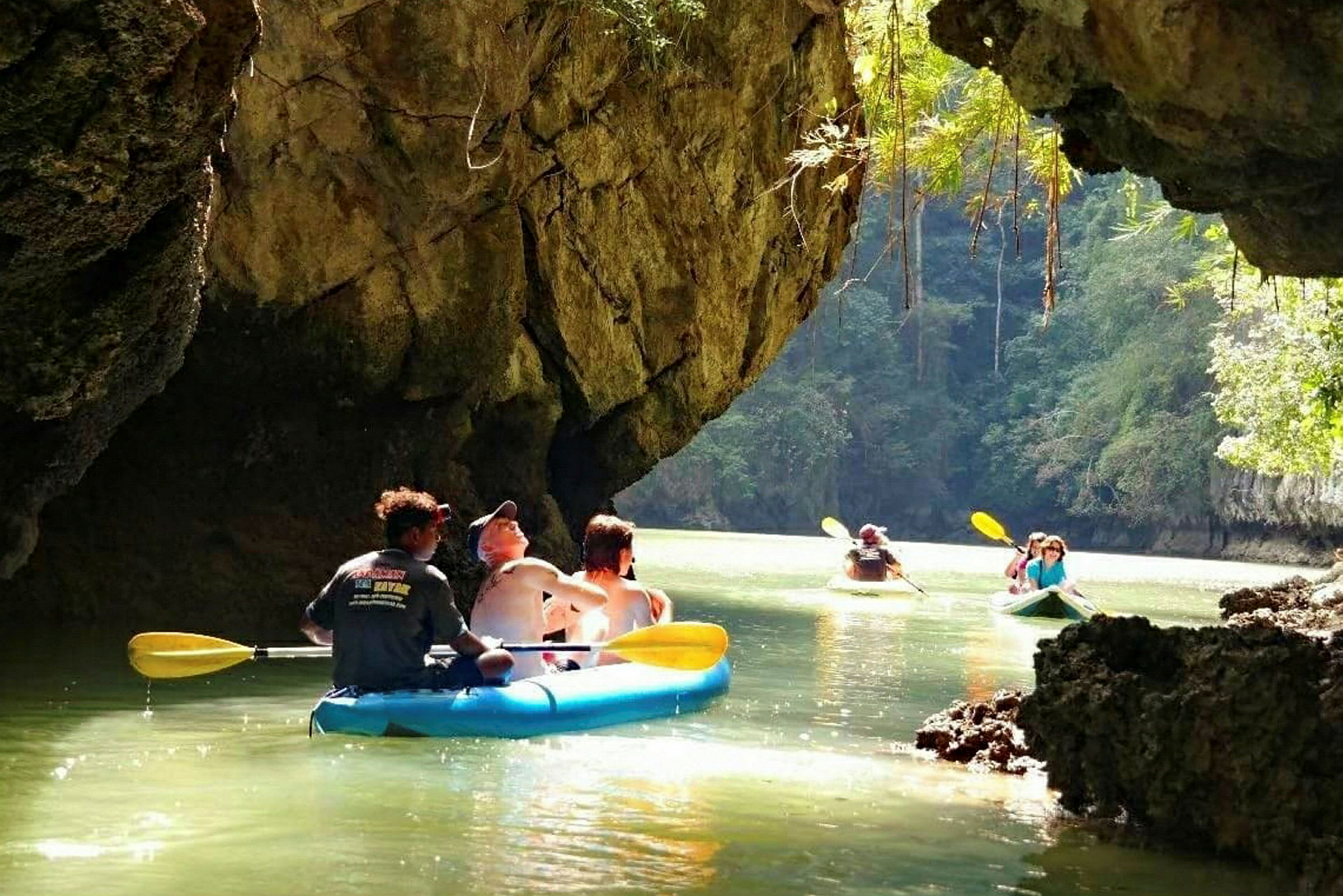 Personer padler kajak i en grotte med vand. (AI-genereret tekst)