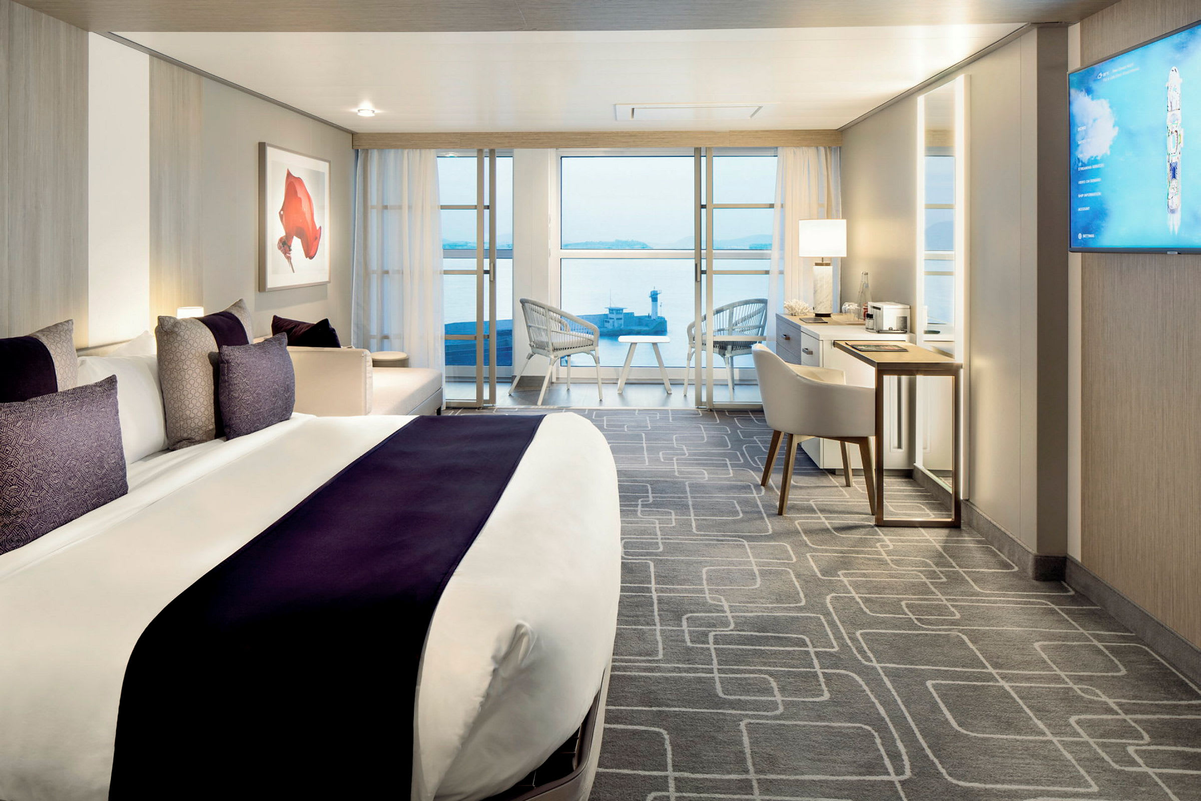 Moderne hotelværelse med en stor seng, siddeområde og udsigt over havet. (AI-genereret tekst)