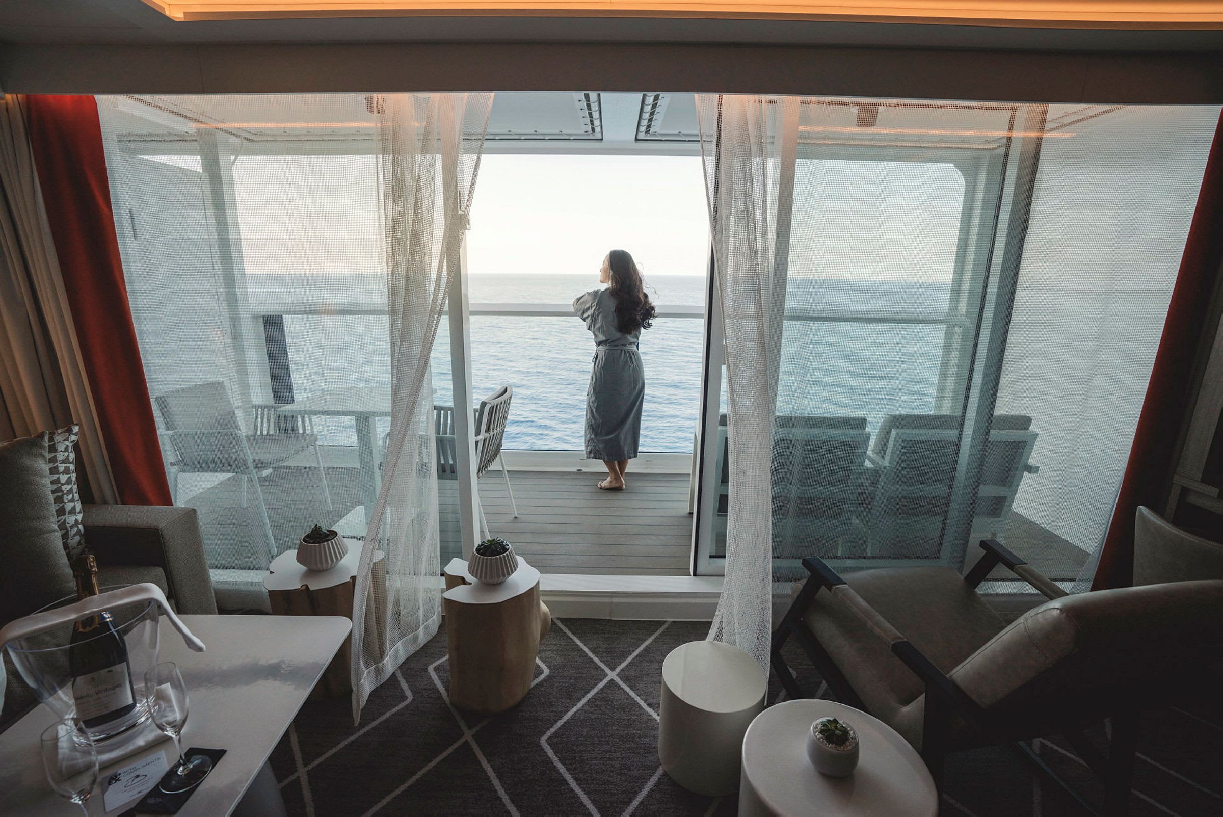 En person står på en balkon og kigger ud over havet. (AI-genereret tekst)