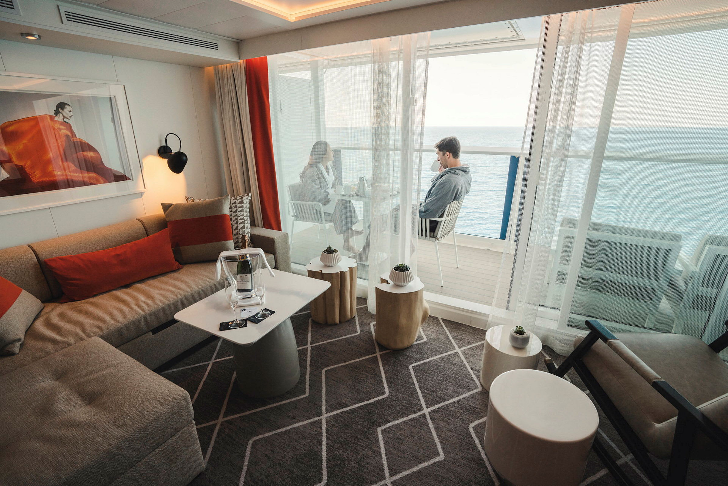 En moderne stue med komfortable møbler og en balkon med udsigt over havet. (AI-genereret tekst)