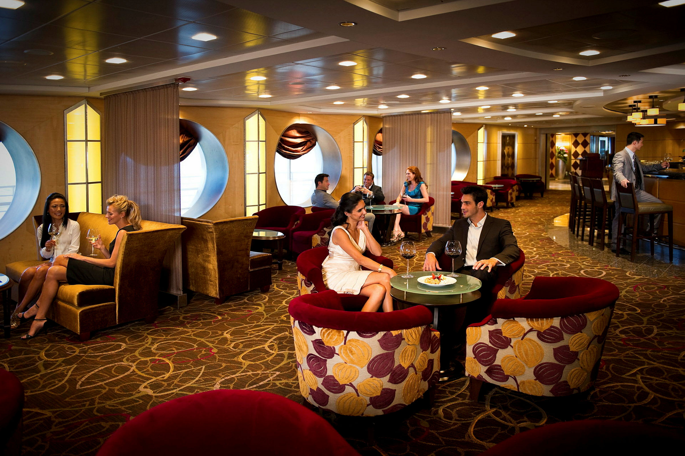 En elegant lounge med personer, der sidder ved borde og nyder mad og drikke. (AI-genereret tekst)