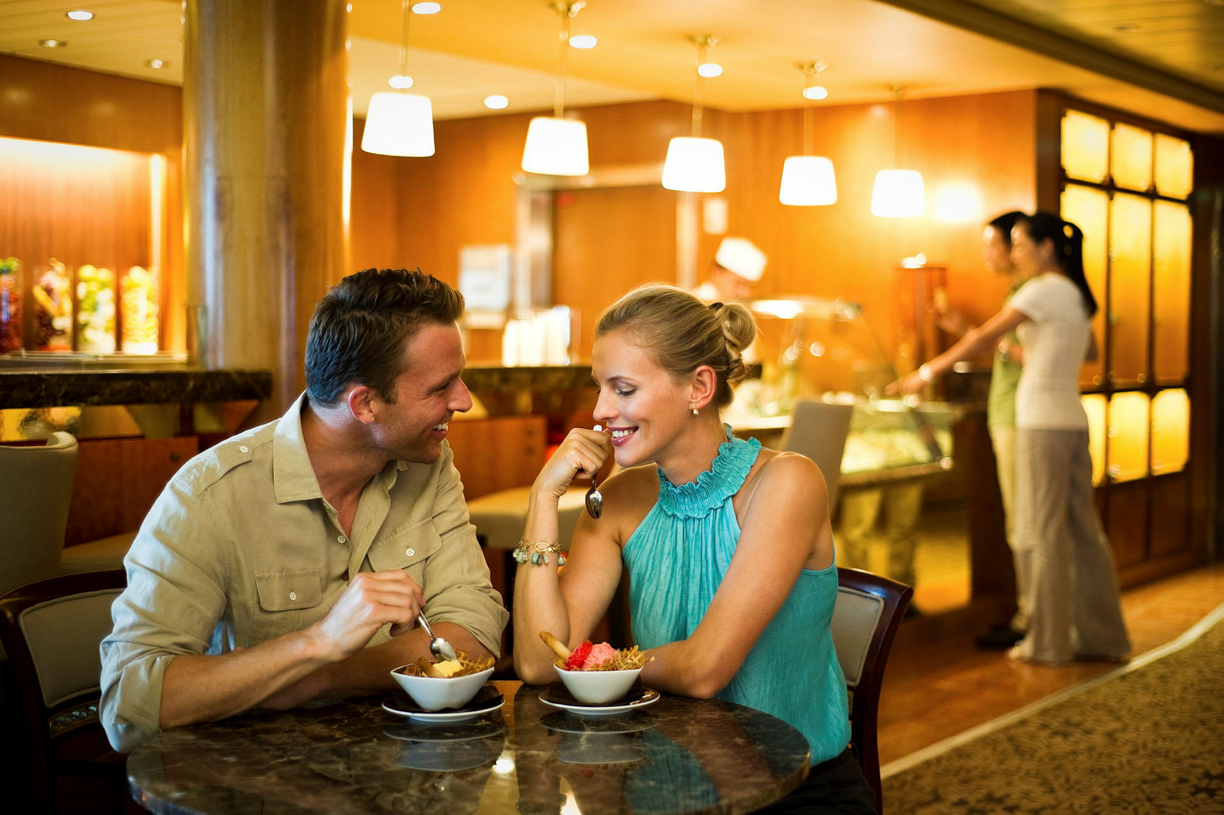 To personer sidder ved et bord og spiser dessert på en restaurant. (AI-genereret tekst)
