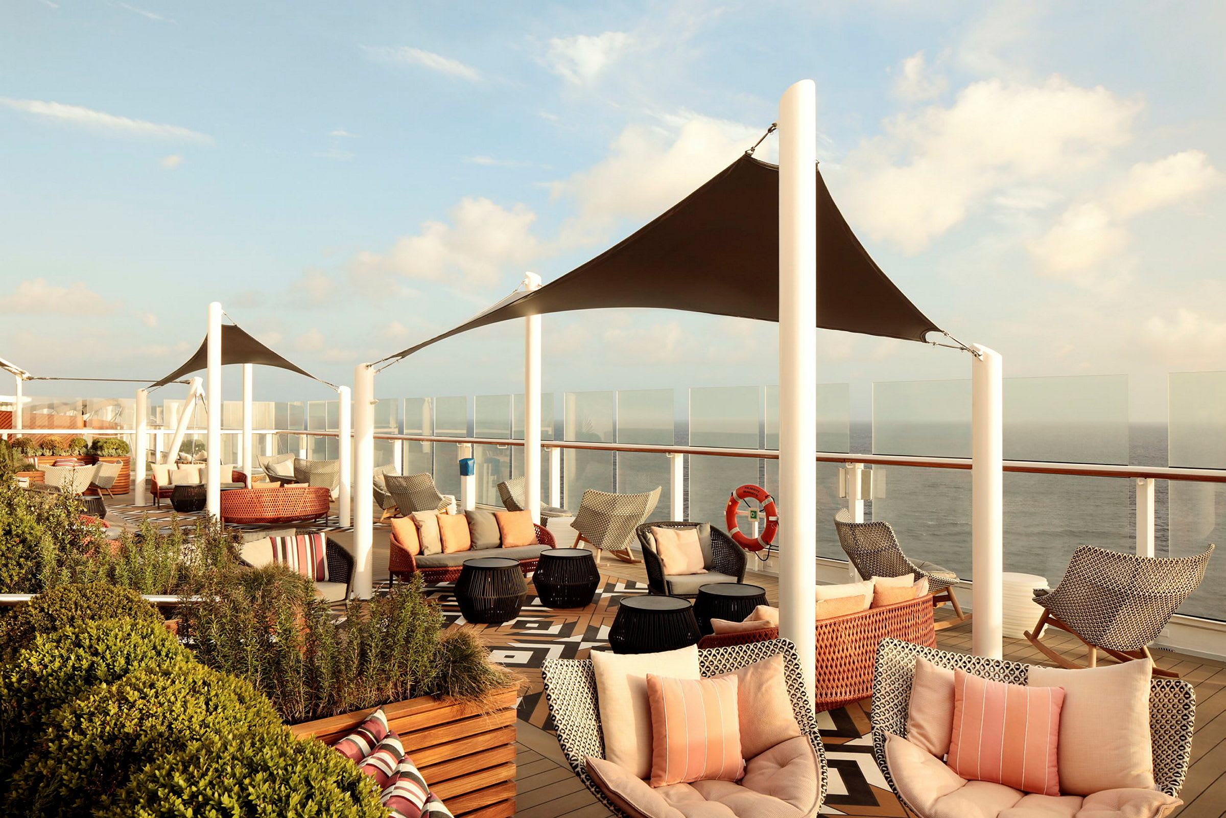 Udendørsmøbler og siddepladser på en solterrasse med havudsigt. (AI-genereret tekst)