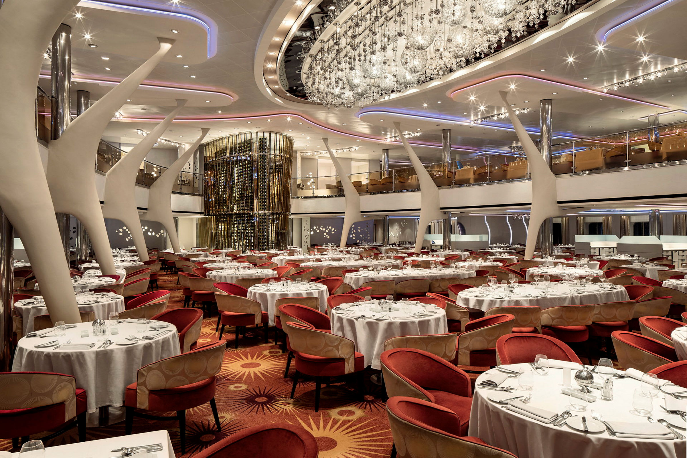 En elegant restaurant med runde borde, hvide duge og røde stole. (AI-genereret tekst)
