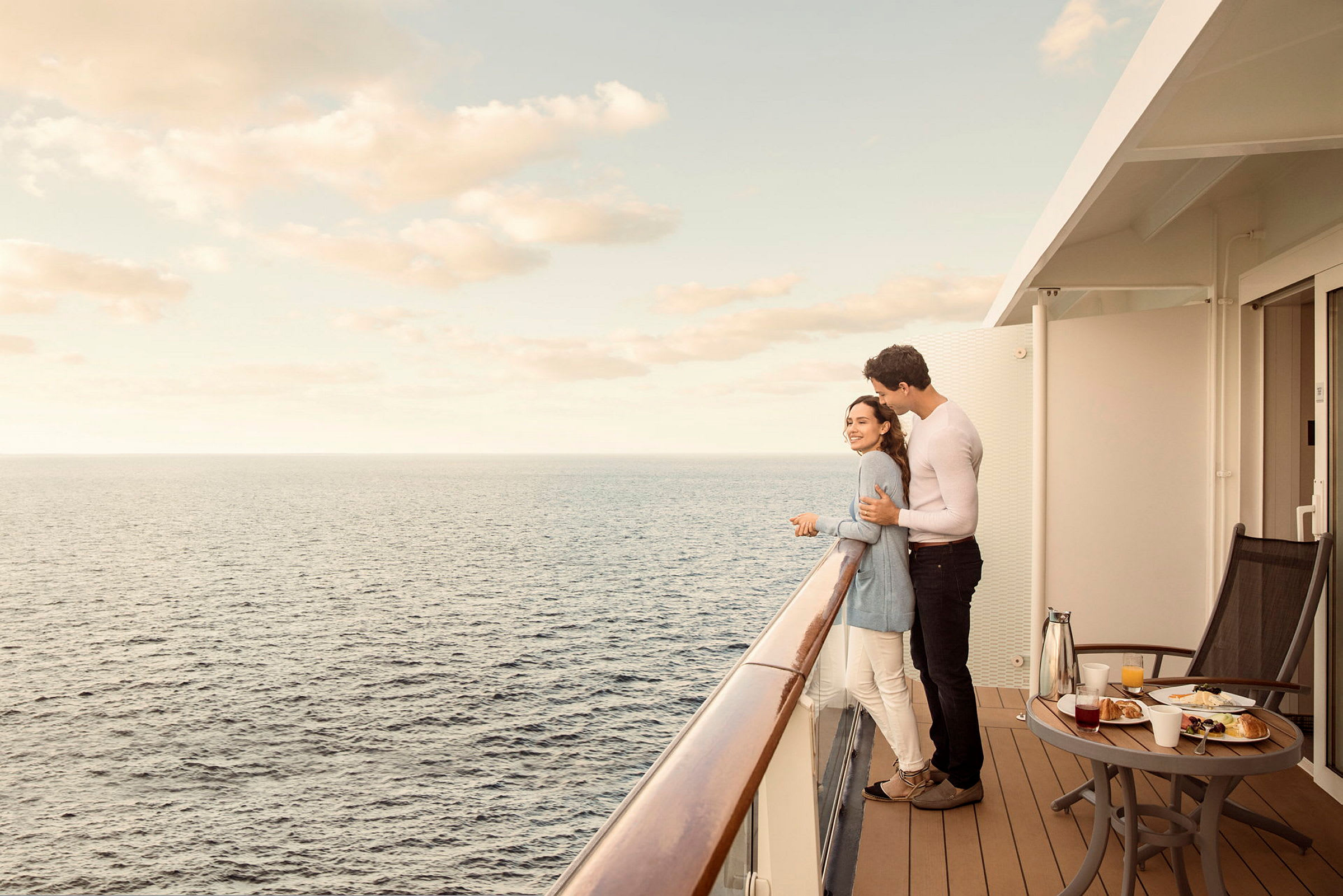 Personer står på en balkon og kigger ud over havet. (AI-genereret tekst)
