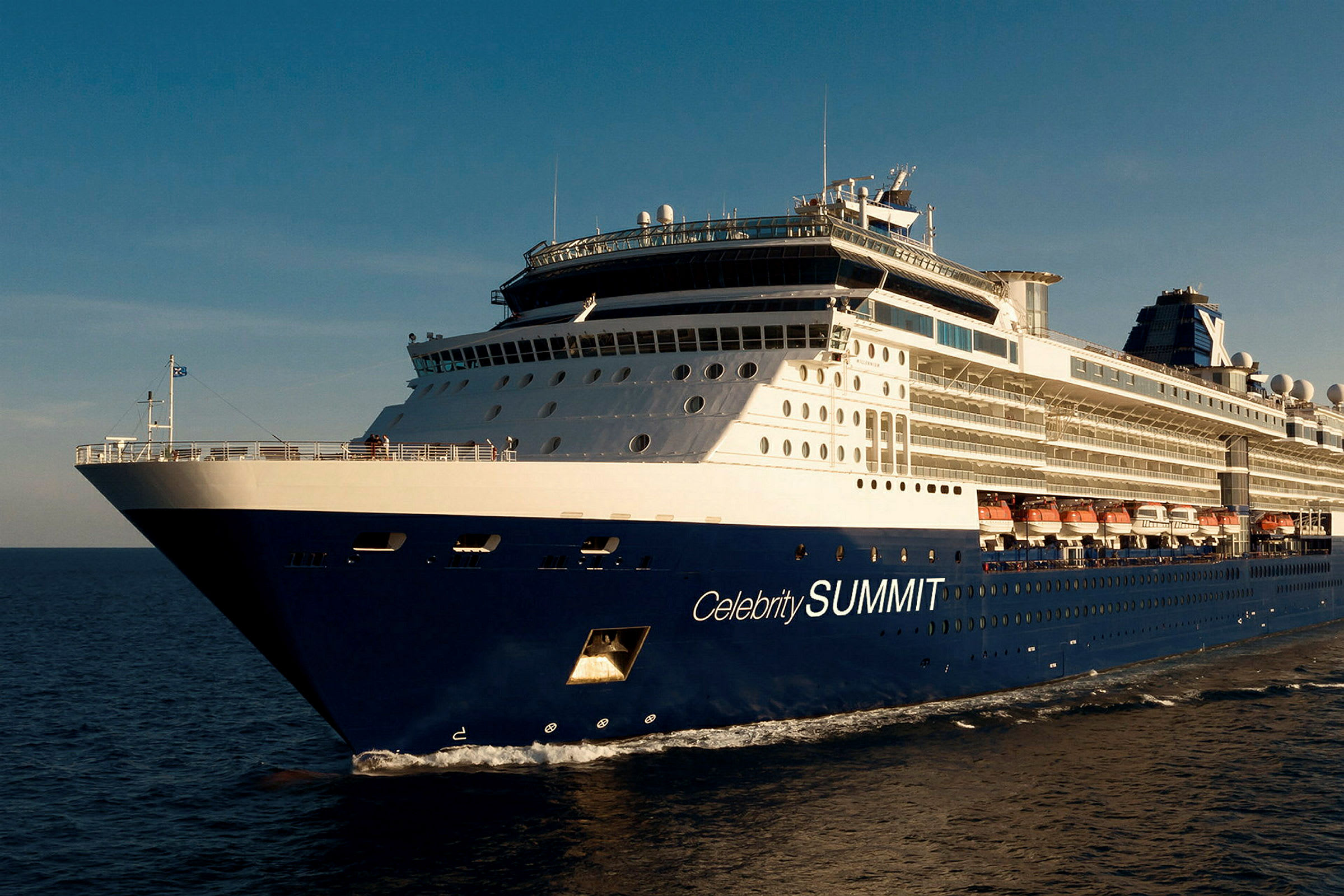 Et blåt og hvidt krydstogtskib med teksten 'Celebrity SUMMIT' på siden, der sejler på havet under en blå himmel. (AI-genereret tekst)