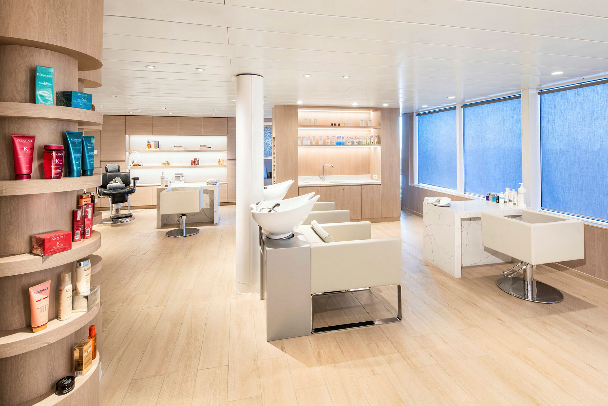 Interiørbillede af en moderne frisørsalon med lyse møbler og produkter på hylder. (AI-genereret tekst)
