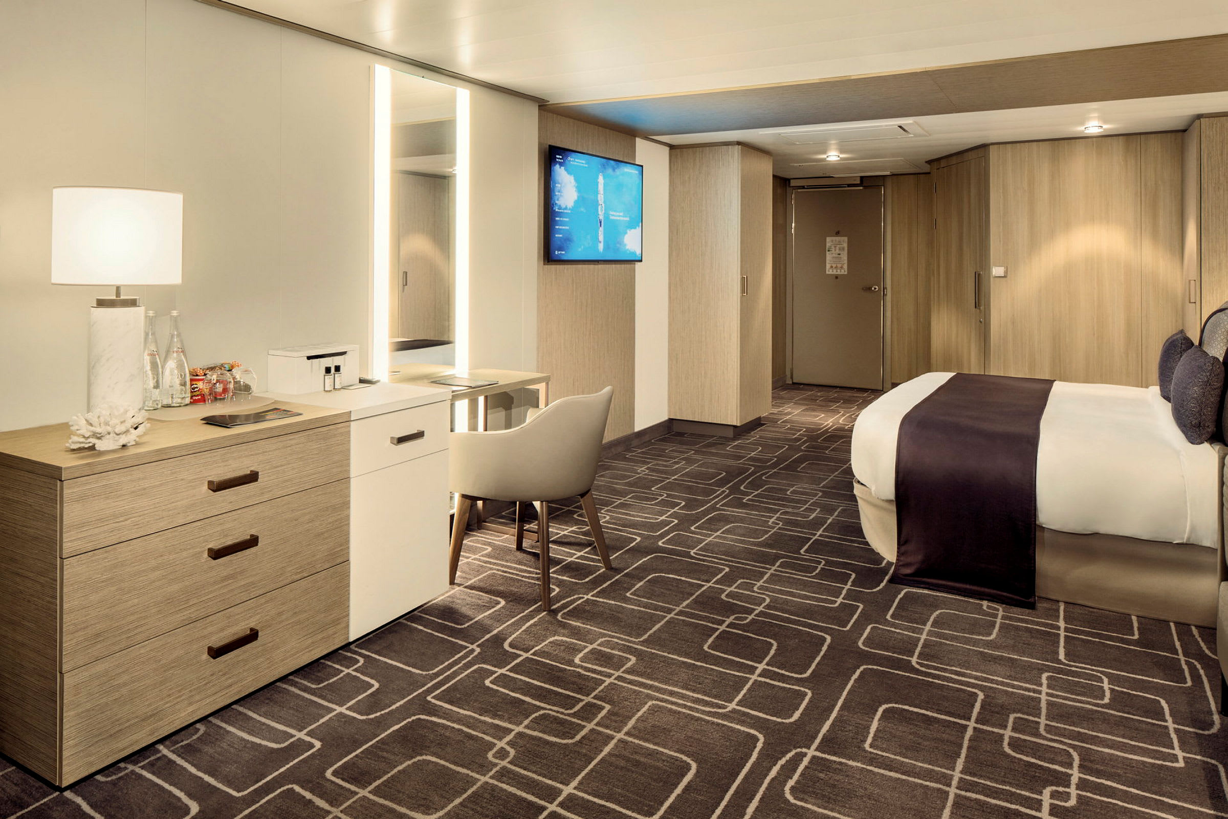Et moderne og rummeligt hotelværelse med en stor seng, skrivebord, stol og garderobeskabe. (AI-genereret tekst)