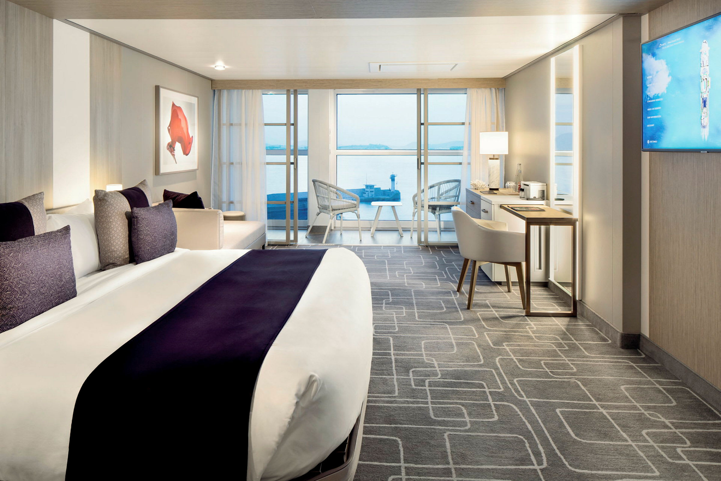 Et moderne og lyst hotelværelse med en stor seng, et skrivebord og en balkon med udsigt over vandet. (AI-genereret tekst)