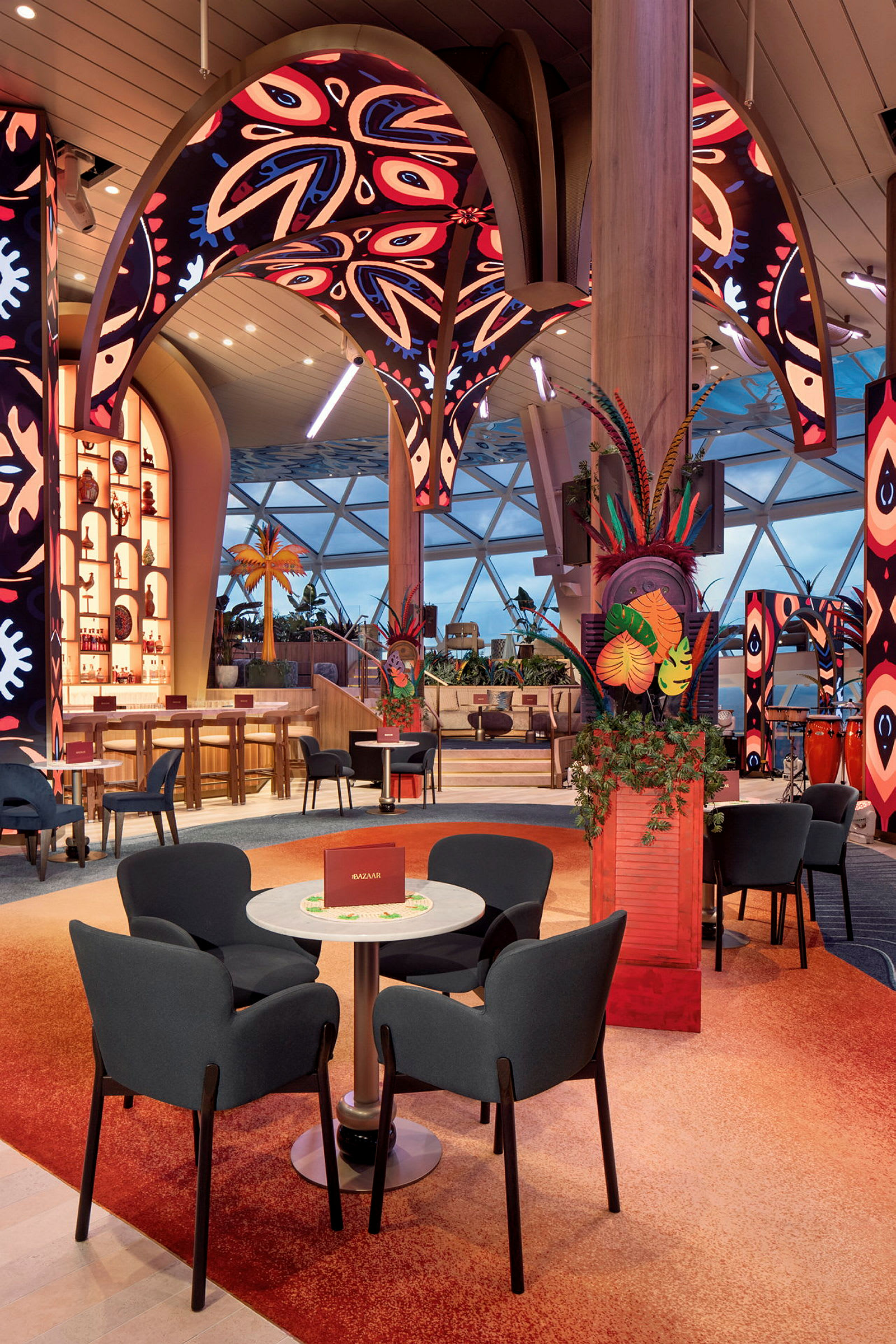 Et interiør af en farverig og moderne restaurant med siddepladser, dekorative plantearrangementer og opsigtsvækkende loftdetaljer. (AI-genereret tekst)