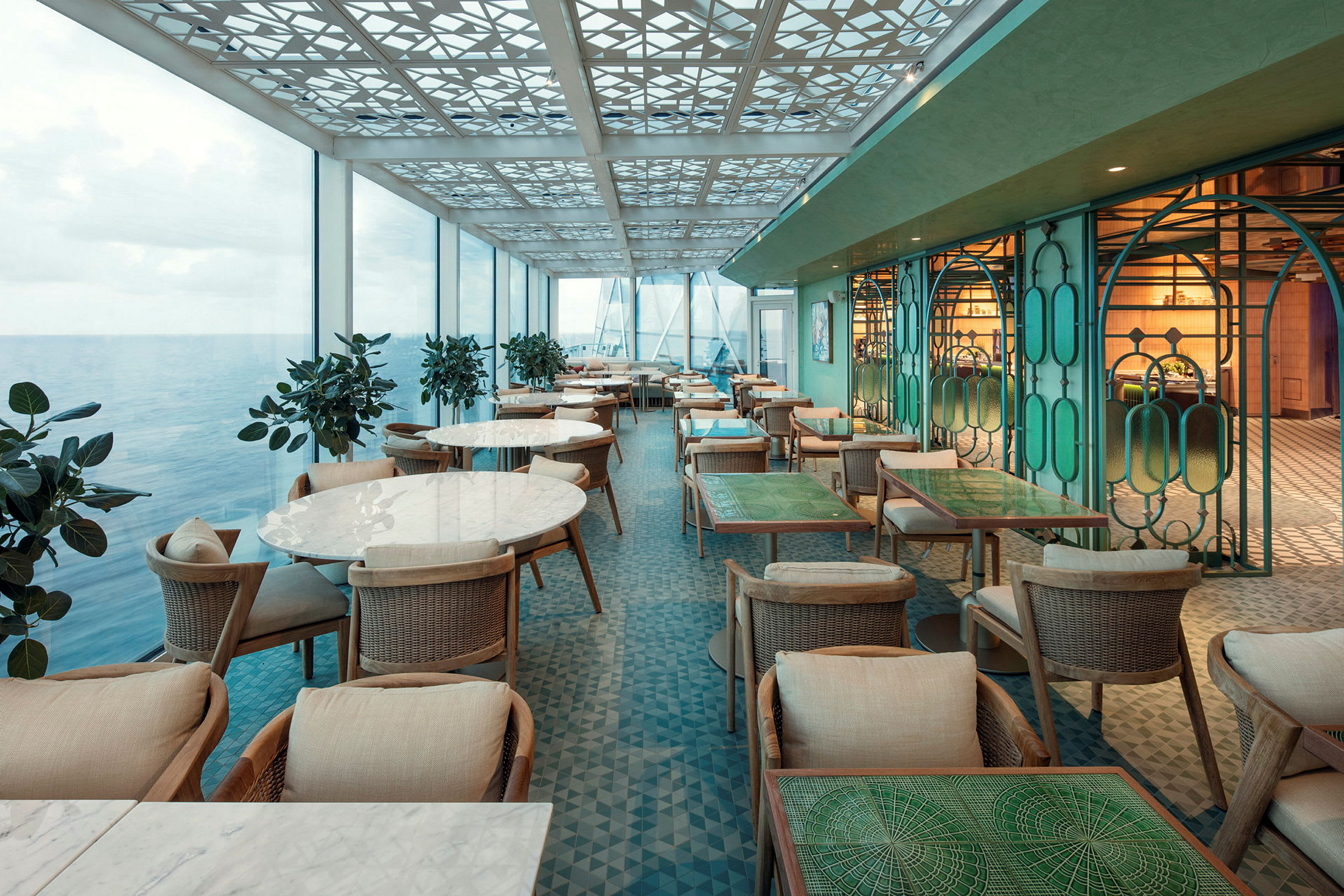 En restaurant med havudsigt, moderne møbler og lyse farver. (AI-genereret tekst)