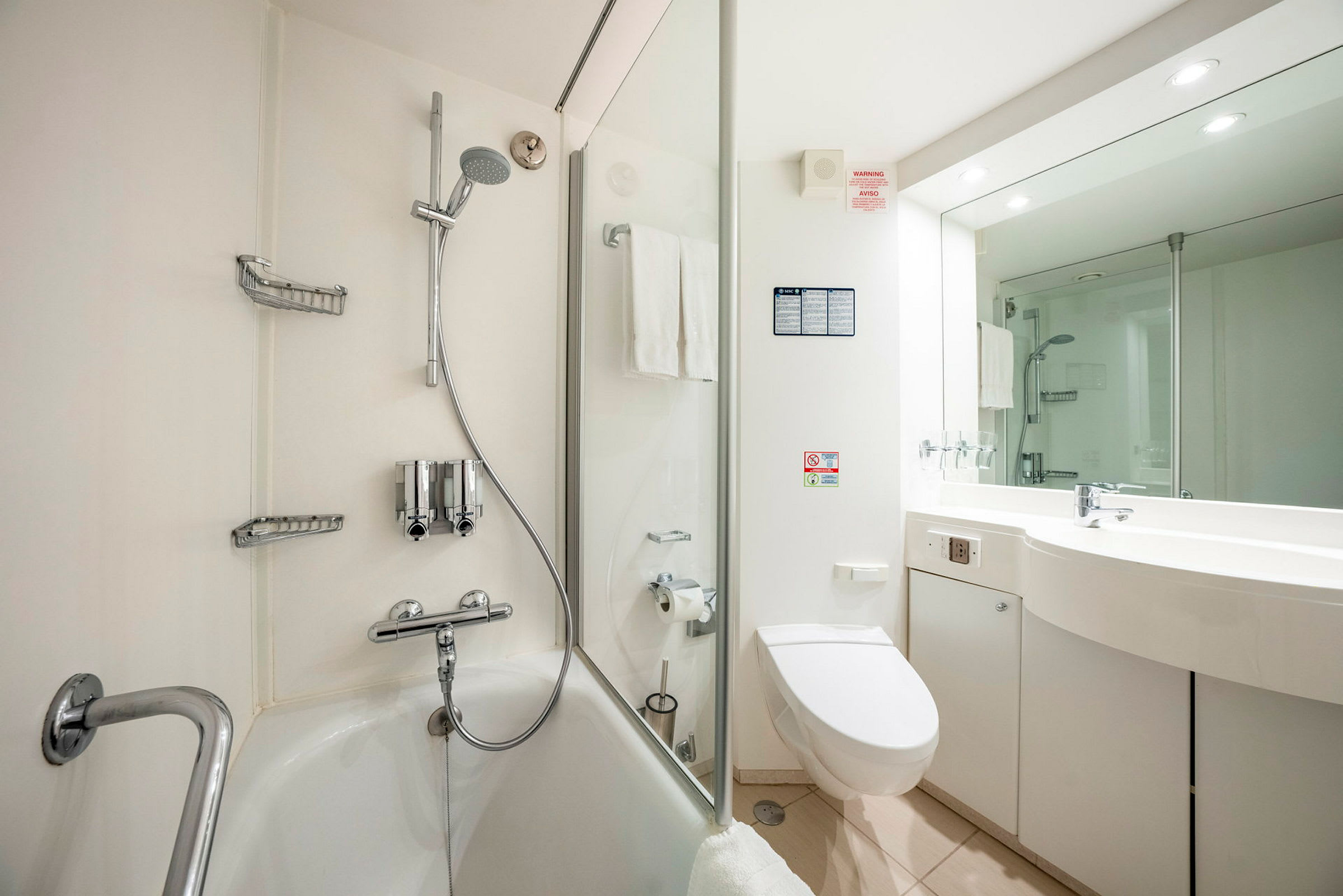 Billede af et rummeligt badeværelse med badekar, bruser, toilet og håndvask. (AI-genereret tekst)