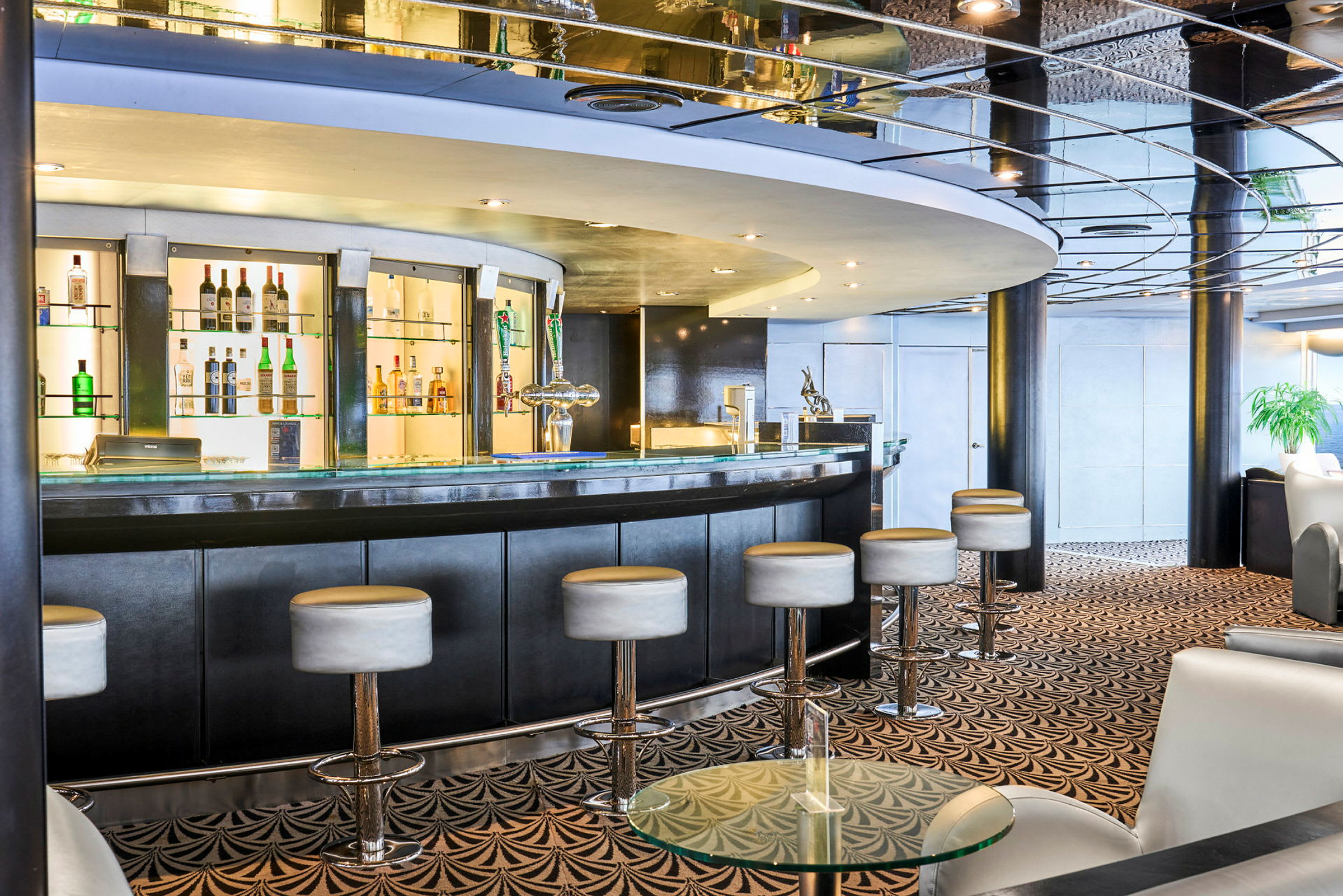Interiør af en elegant bar med en buet bardisk og høje barstole. (AI-genereret tekst)