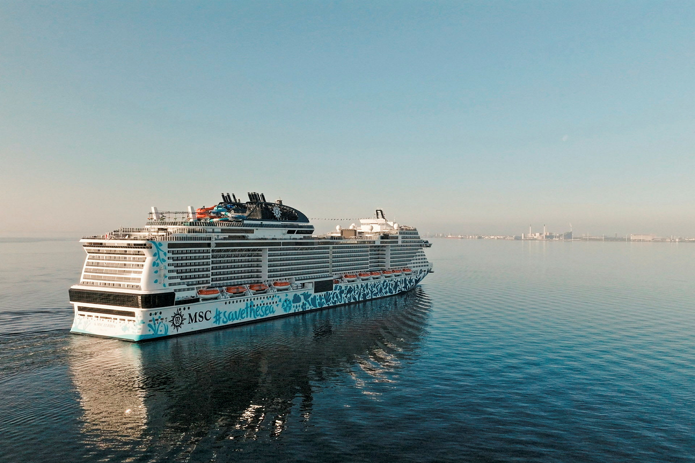 Et krydstogtskib på havet med en by i baggrunden. (AI-genereret tekst)