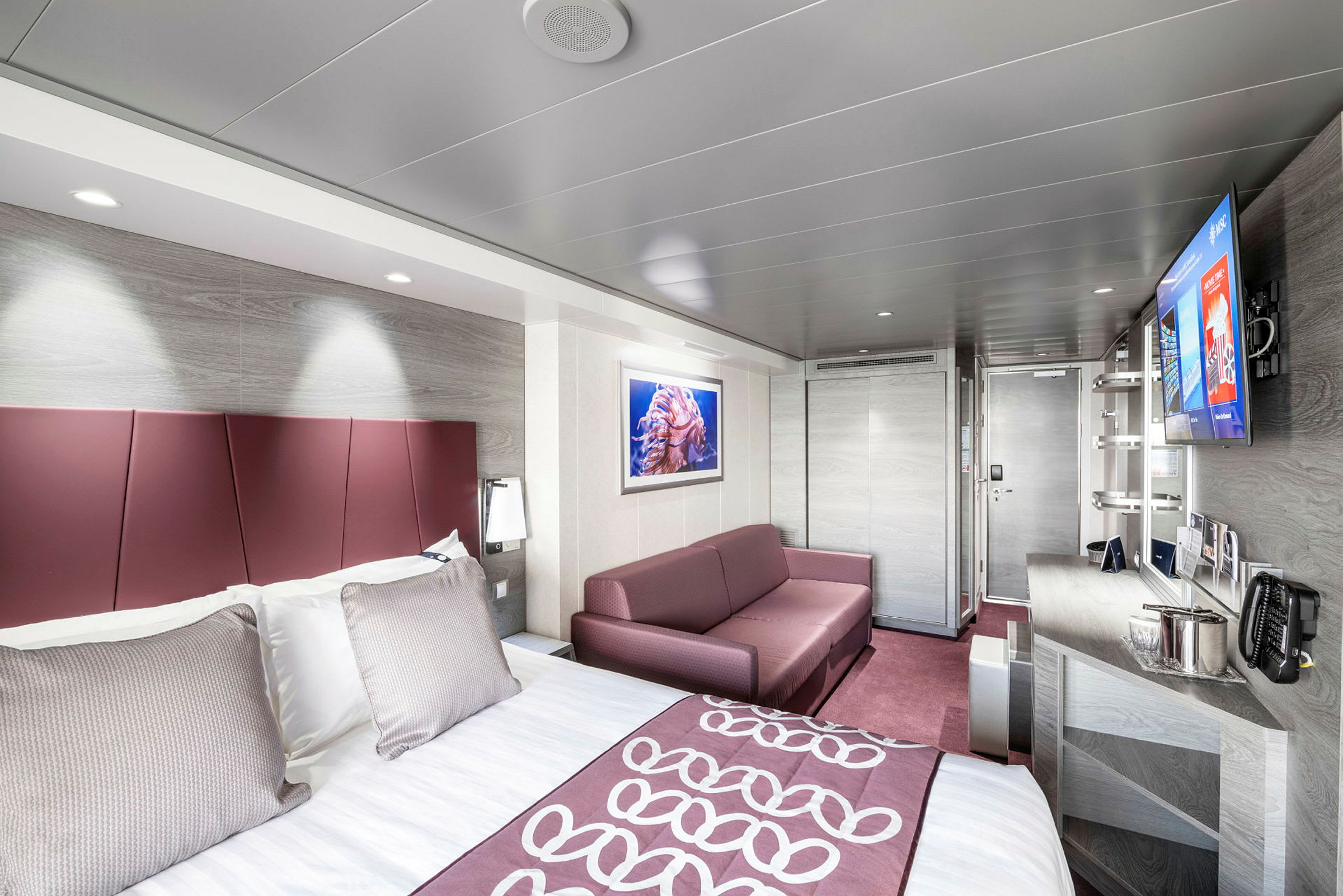 Hotelværelse med seng, sofa og indretning. (AI-genereret tekst)