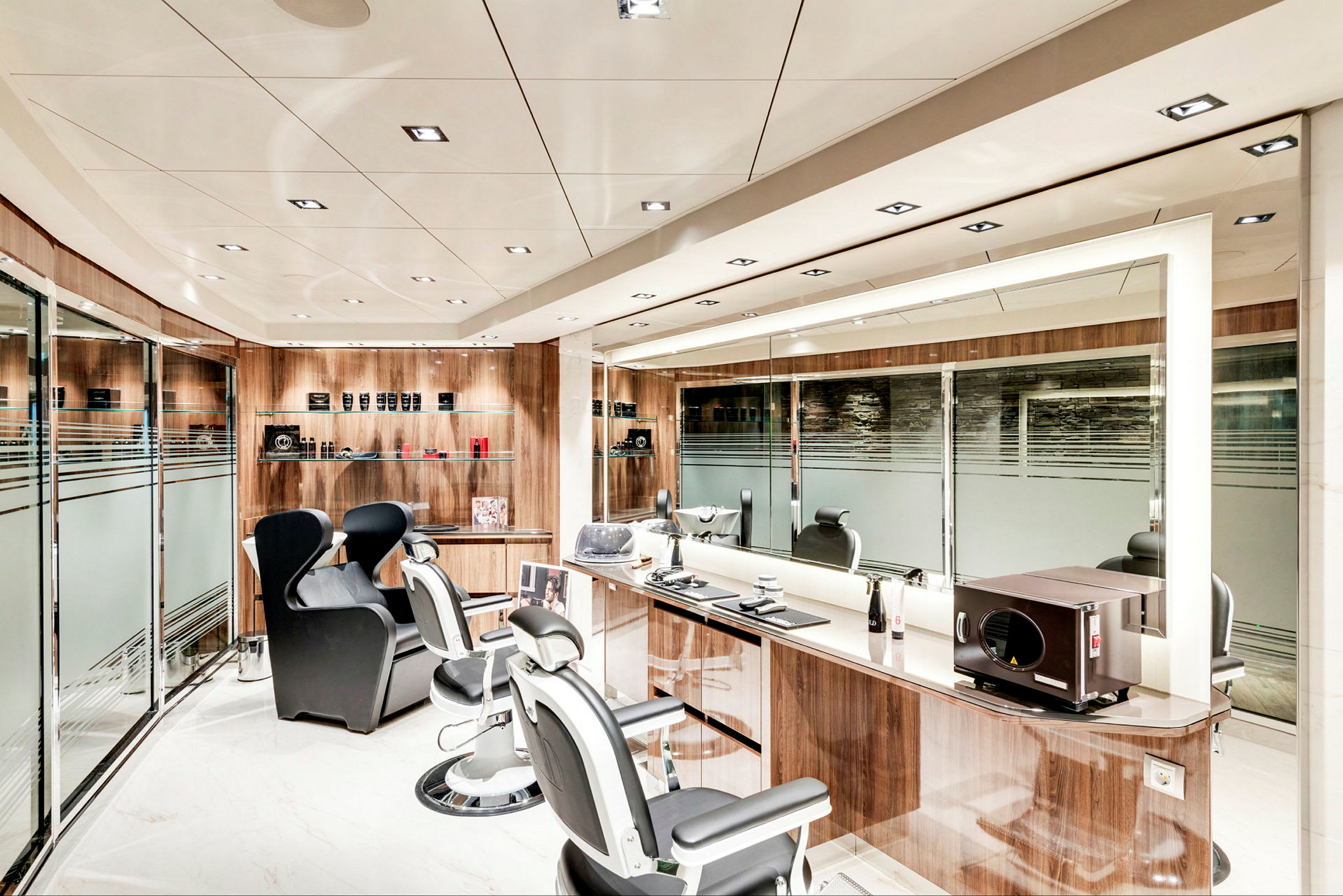 En moderne frisør- og barbershop med tre frisørstole, spejle og hylder med produkter. (AI-genereret tekst)