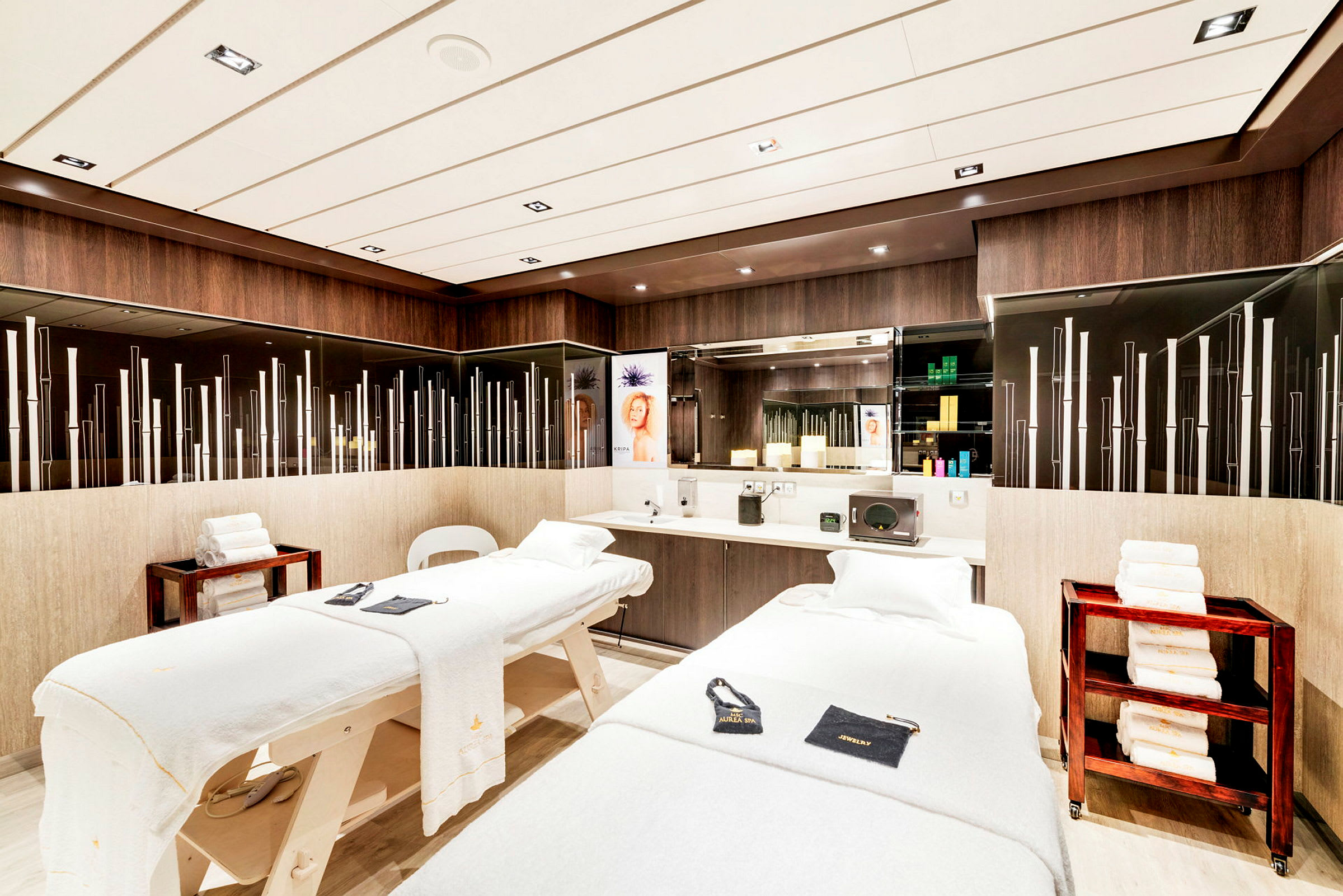 Billede af et elegant spa-rum med to massageborde og dekorative elementer. (AI-genereret tekst)