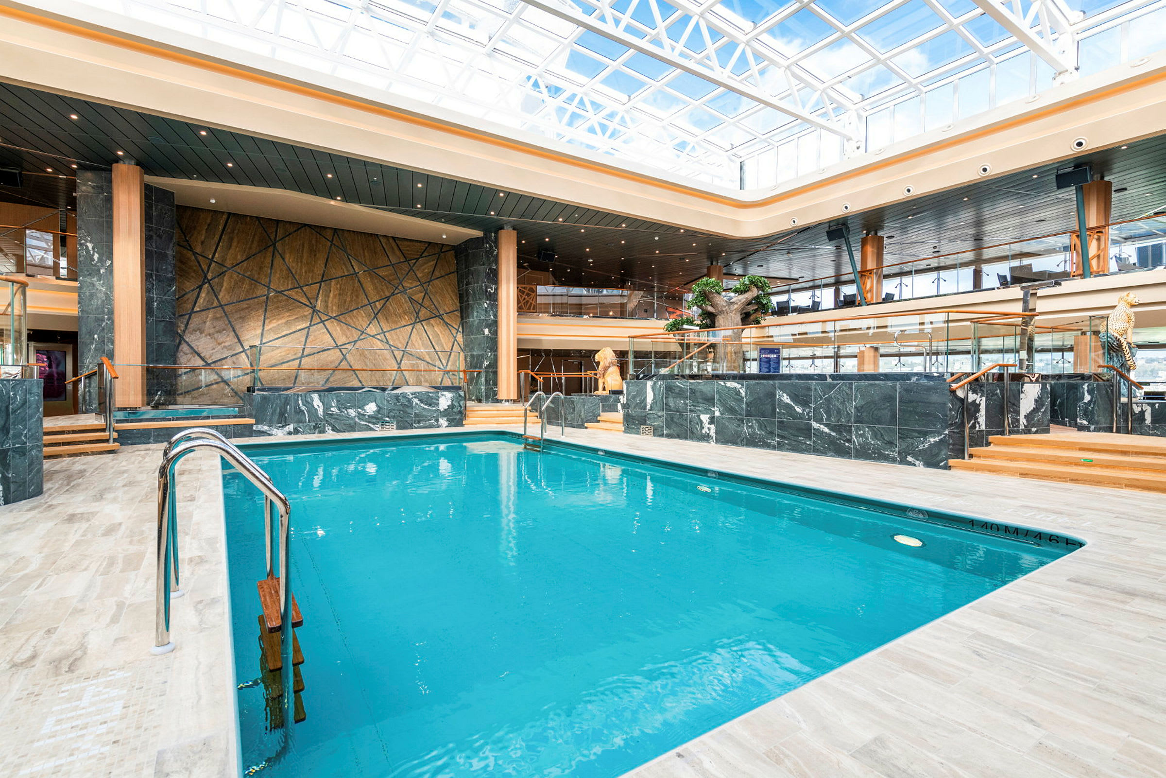 En indendørs pool med moderne indretning og store vinduer omkring. (AI-genereret tekst)