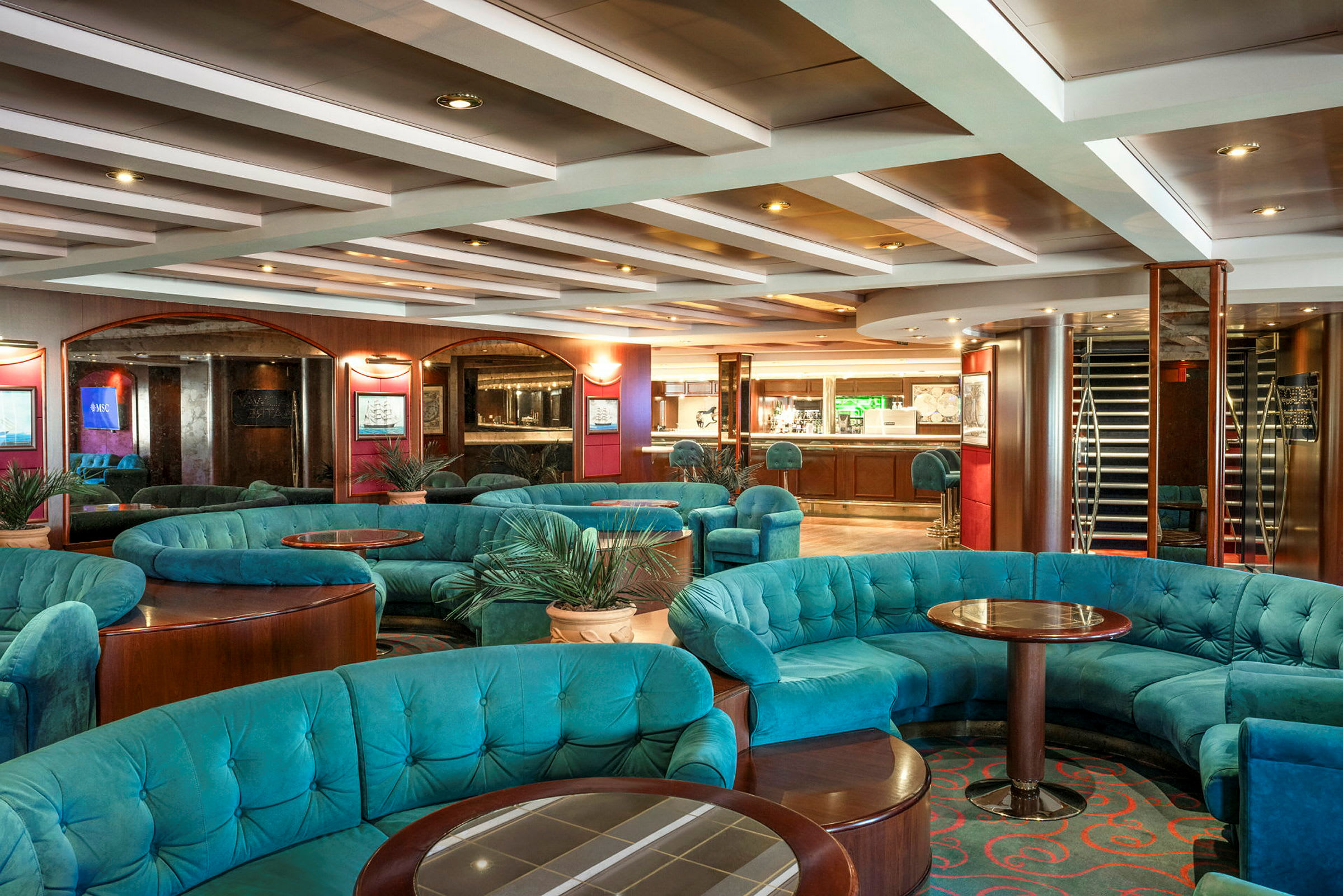 En elegant lounge med turkise sofaer, runde borde og en indbydende atmosfære. (AI-genereret tekst)