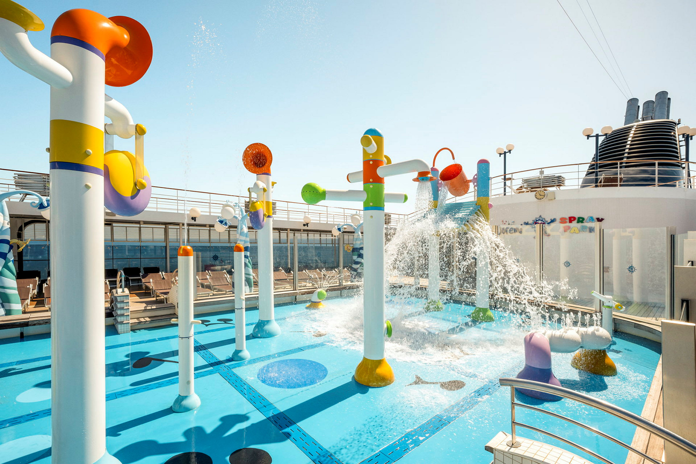 Farverige vandlege og springvand ved en pool på et skibsdæk. (AI-genereret tekst)