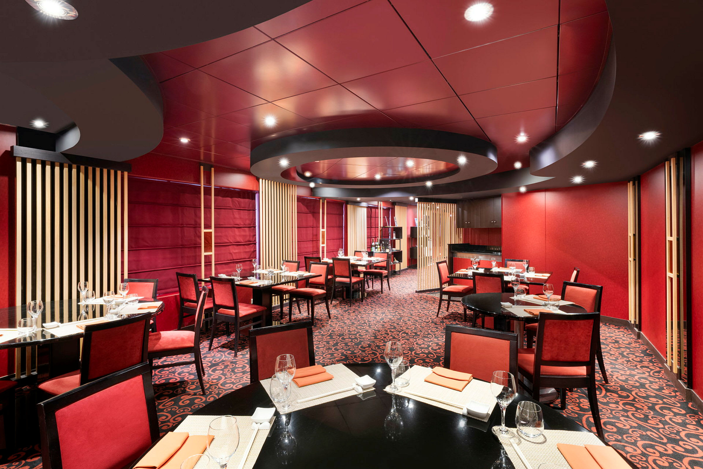 Interiør af en restaurant med rødt farvetema og dækkede borde. (AI-genereret tekst)