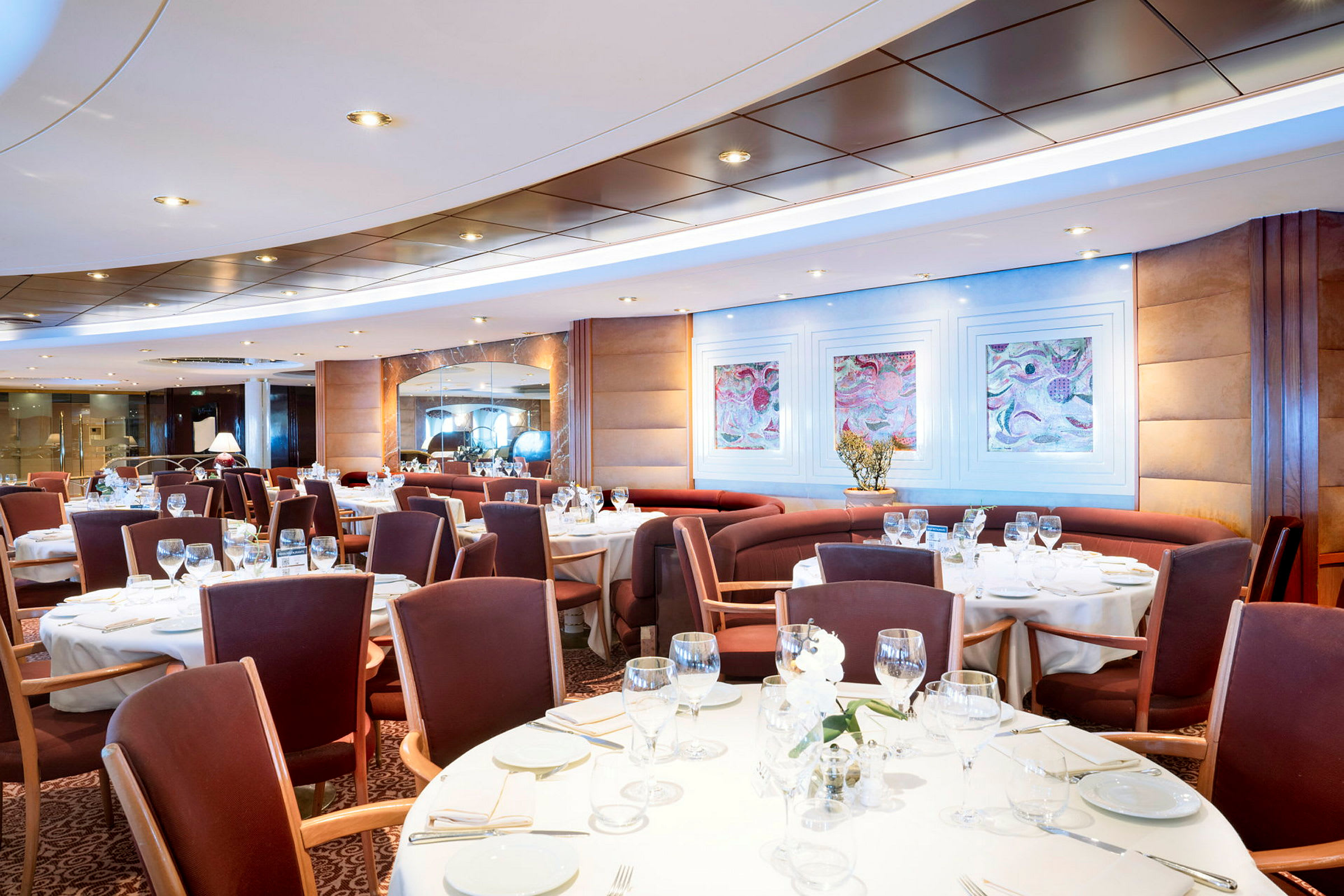 En elegant restaurant med dækkede borde og stole omkring dem. (AI-genereret tekst)