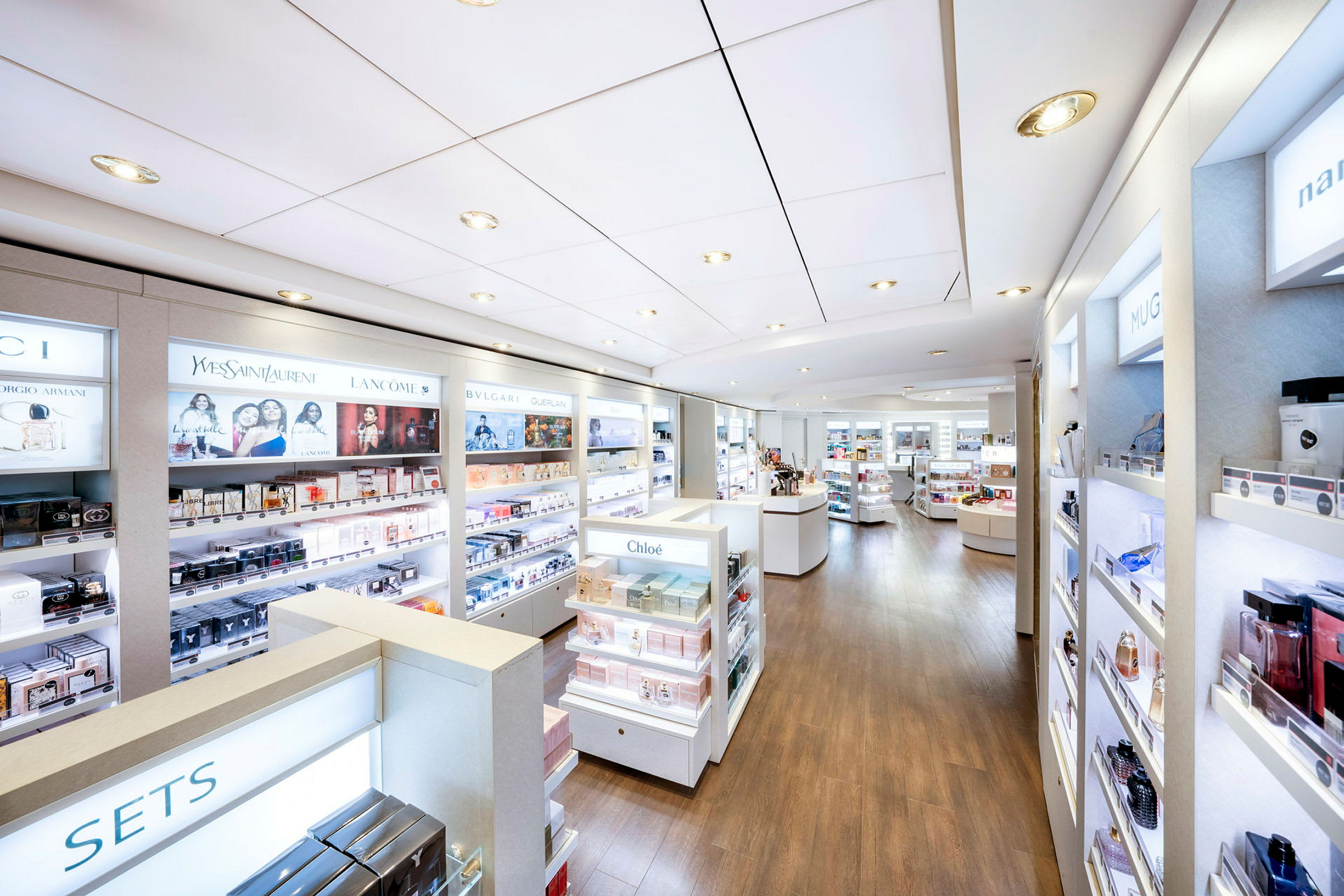 Interiør i en lys og moderne parfume- og kosmetikbutik med produkter arrangeret på hylder. (AI-genereret tekst)