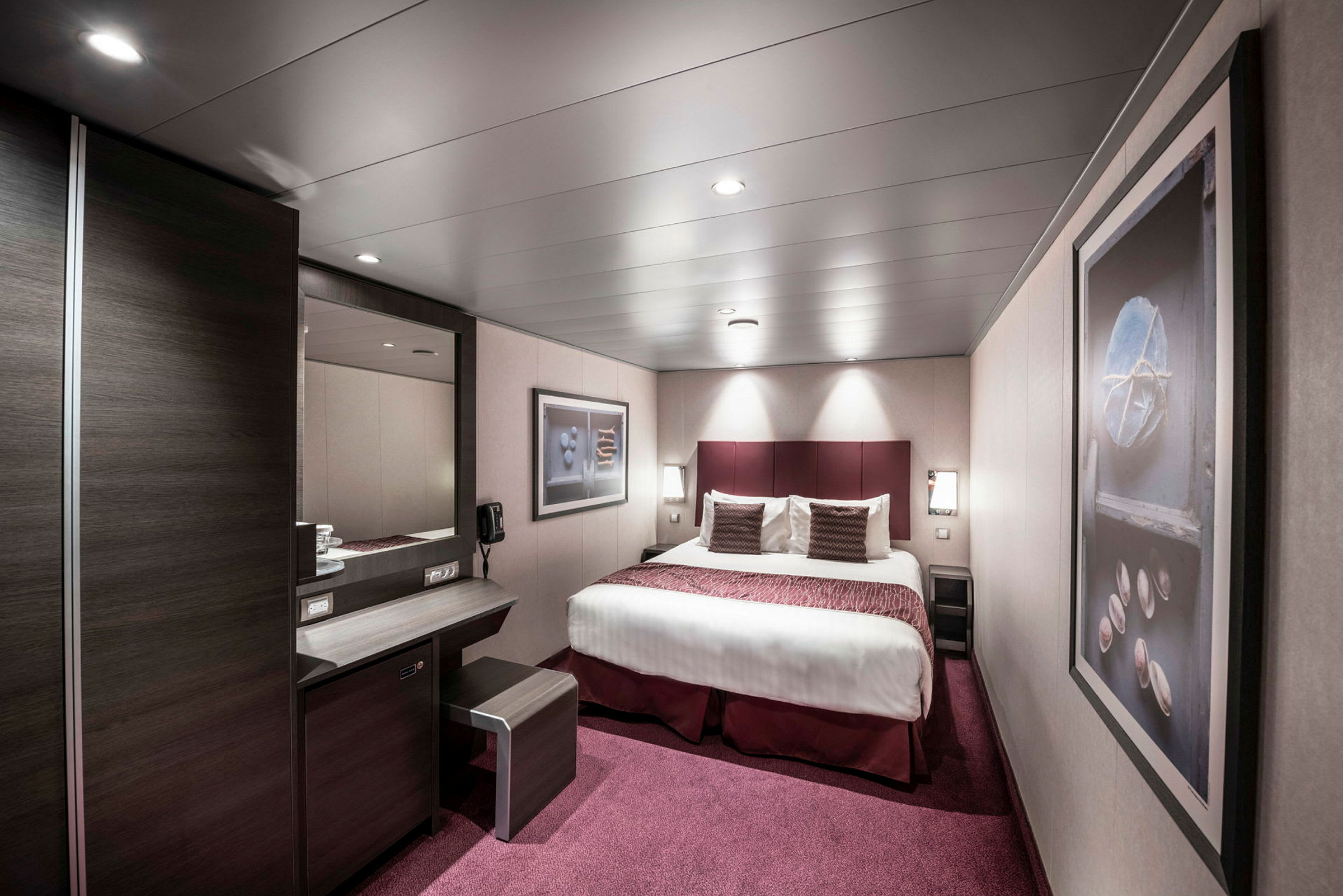 Et elegant hotelværelse med en dobbeltseng, skrivebord og vægkunst. (AI-genereret tekst)